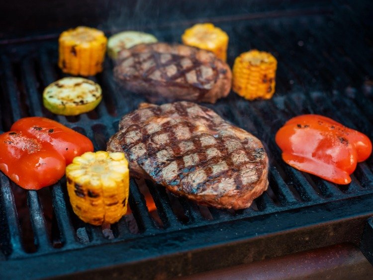 Grillgut aus Fleisch und Gemüse bruzzelt auf dem Rost