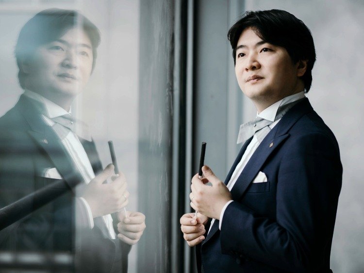 Der japanische Dirigent Kazuki Yamada im Anzug mit Dirigentenstab