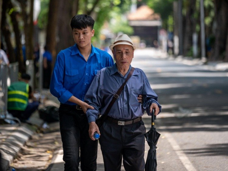 Ein junger Vietnamese stützt einen vietnamesischen Senior