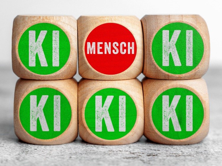 gestapelte Würfel: fünf mit der Aufschrift KI, einer mit der Aufschrift Mensch