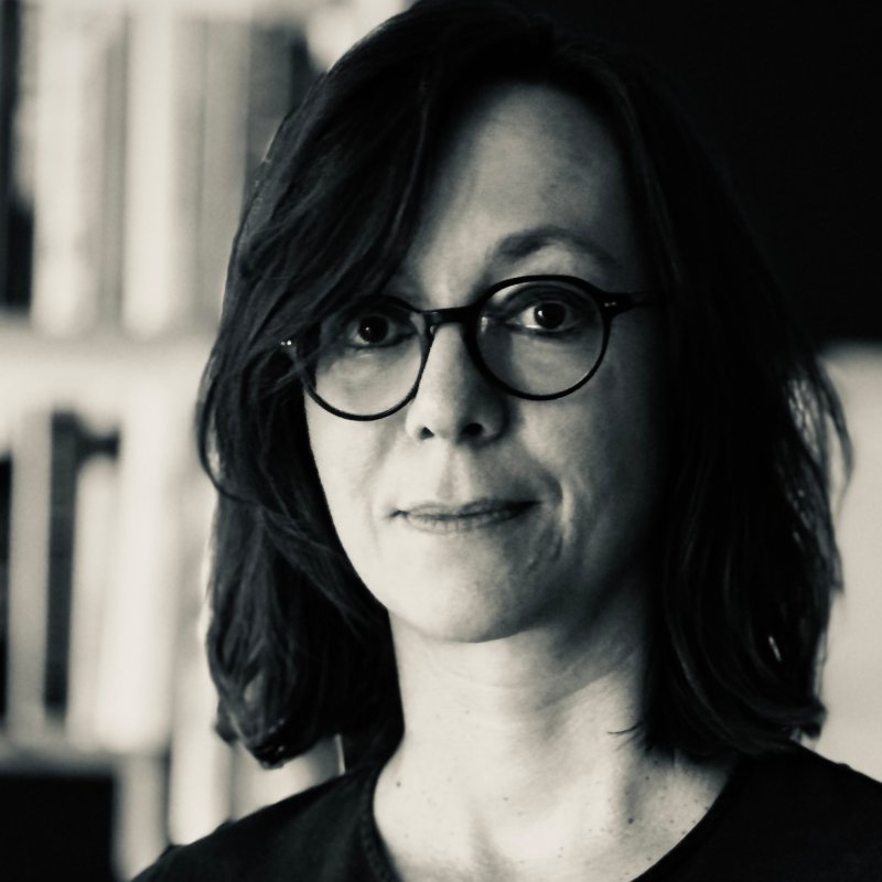 Portrait einer dunkelhaarigen Frau mit Brille vor weißem Hintergrund