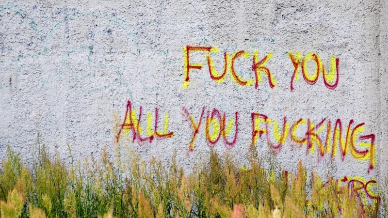 Graffiti mit Hatespeech an einer grauen Hauswand