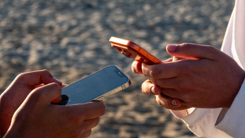 zwei Jugendliche halten Handys in Händen