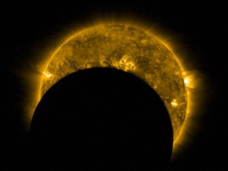 Vor der gelben, stark strukturierten Sonnenoberfläche steht die schwarze Scheibe des Mondes. Von der Sonne ist nur noch eine Sichel zu sehen.