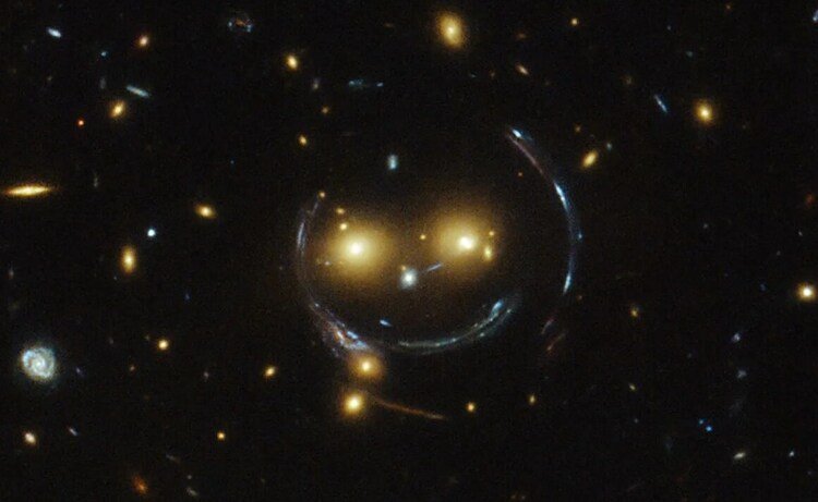 In einer Wüstenlandschaft stehen mehrere Radioteleskope, die wie riesige Satellitenschüsseln aussehen. Über den gestirnten Himmel darüber zieht eine sehr helle Sternschnuppe
